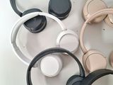 several headphones sitting on top of each other on a white surface