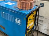 a blue machine with a copper pot on top of it