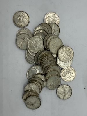 a pile of silver coins sitting on a white surface