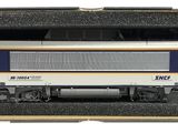 un petit train dans une boîte posée sur une surface blanche