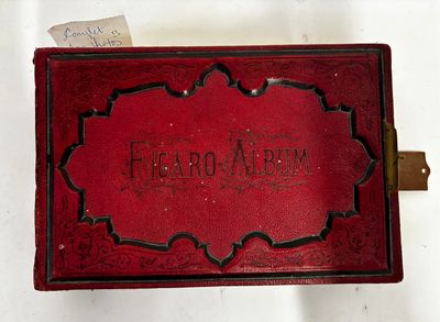un vieux livre rouge, sur lequel sont inscrits des mots, posé sur une table