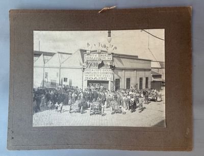 une vieille photo d'un groupe de personnes se tenant devant un bâtiment