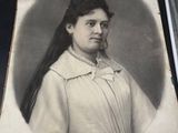 an old picture of a woman with long hair in a white dress