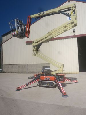 a picture of a man on a cherry picker in front of a building