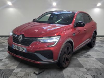une voiture rouge garée dans un garage au sol en damier