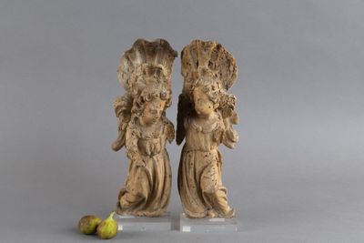 deux figurines d'anges debout à côté d'une banane