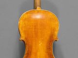 an old violin with a wooden back and bow on a gray background