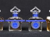 three small bottles of perfume are lined up on a black surface