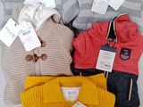 three pairs of sweaters with tags on them sitting next to each other