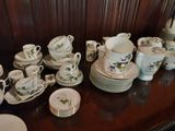 a lot of dishes and cups sitting on a table