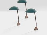 three green table lamps sitting on top of a white surface