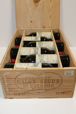 bouteilles de vin dans un coffret en bois sur une surface blanche