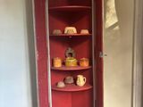 a red corner cabinet in the corner of a room