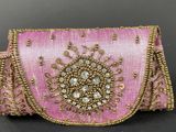 a close up of a pink purse on a black surface