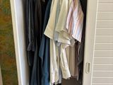 an image of a closet with clothes hanging in it