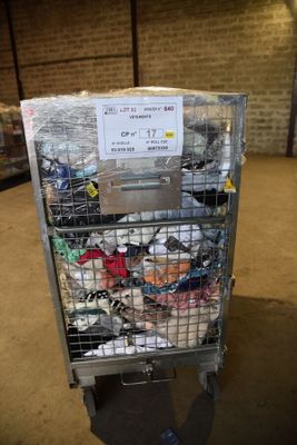 un chariot métallique contenant de nombreux articles, dans un entrepôt