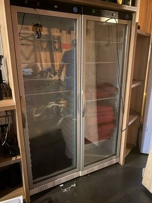 a picture of a refrigerator in a room with a lot of clutter on the floor