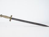 une vieille épée avec une poignée en or sur une surface blanche
