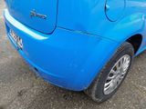 a small blue car parked in a parking lot