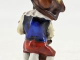 a figurine of a man sitting on a toilet with a hat on his head