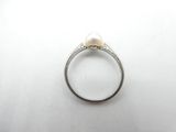 a close up of a ring with a pearl on it