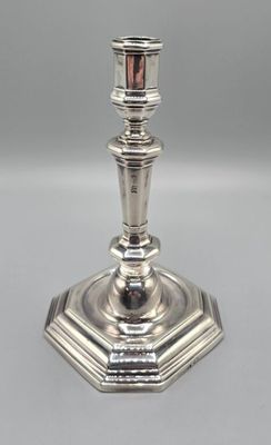 a silver plated candle holder sitting on top of a table