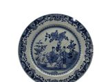 une assiette bleue et blanche sur laquelle sont représentés un homme et une femme