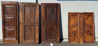 quatre portes en bois alignées les unes à côté des autres dans un parking
