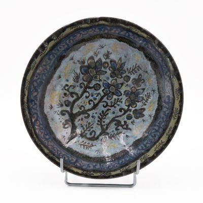 a blue and black plate with a tree on it