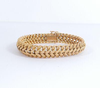 un bracelet en or avec un motif de tresse sur fond blanc