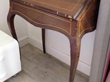 un petit bureau muni d'un tiroir, placé dans un coin de la pièce