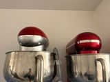 deux mixeurs rouges posés sur une étagère bleue