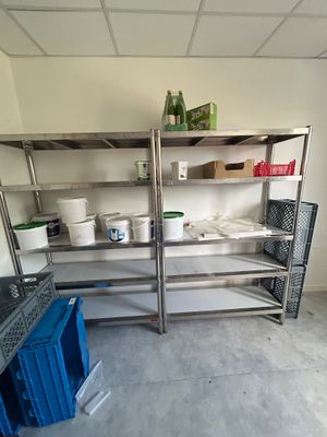 a metal shelf with pots and pans on top of it