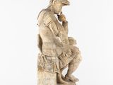 a statue of a man sitting on top of a stone block