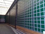 a green wall with metal bars on it in a warehouse