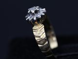 a close up of a gold ring with a diamond on it