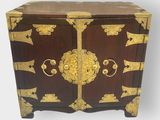 an image of a wooden chest with a gold decoration on it