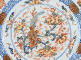a close up of a blue and white plate with flowers on it
