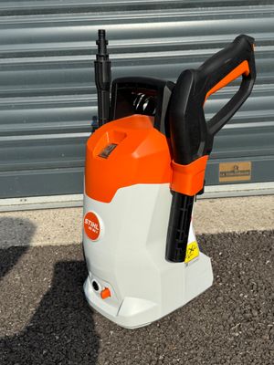 un ventilateur électrique orange et blanc posé au milieu d'un parking