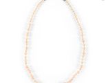 a close up of a beaded necklace on a white background