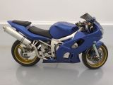 a blue motorcycle parked on a white floor in a room