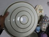 a person holding a white plate with a gold rim