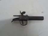gros plan d'un pistolet sur une table à fond blanc