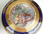 a blue and gold plate with a painting on it