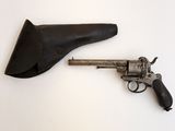 un vieux pistolet dans un étui en cuir posé sur une surface blanche