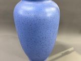 a blue vase that is sitting on a table