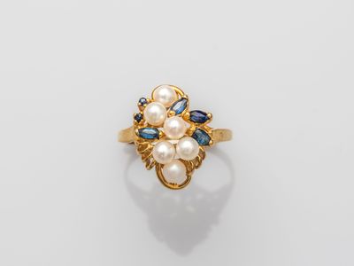a gold ring with pearls and sapphires