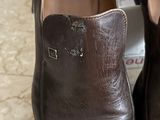 pair of brown leather shoes sitting on top of a marble counter top