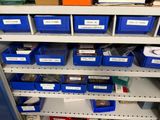 many bins on the shelves with labels on them