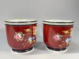 pair of red and white cups with floral designs on them
